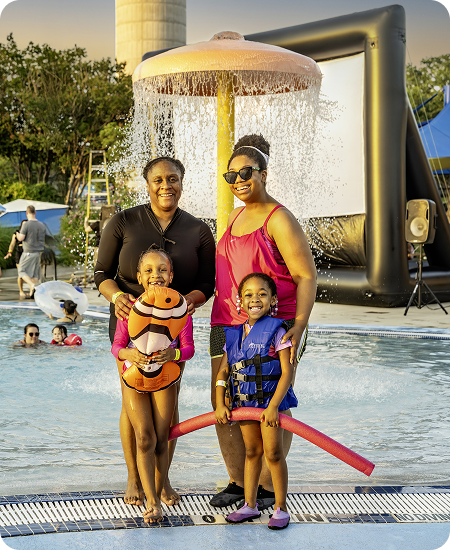 A family standing under the water shower in the aquatic park